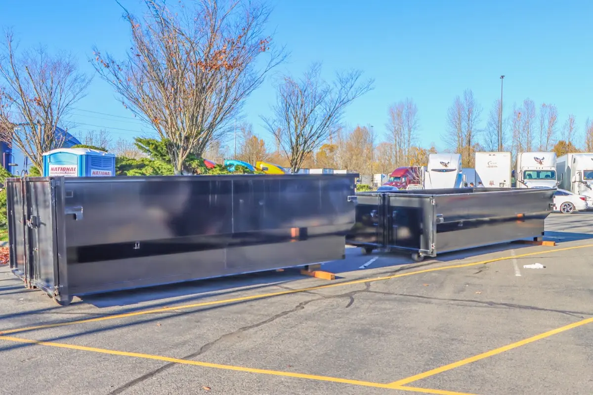 Professional dumpster rental service with roll-off container on residential driveway in Corrales